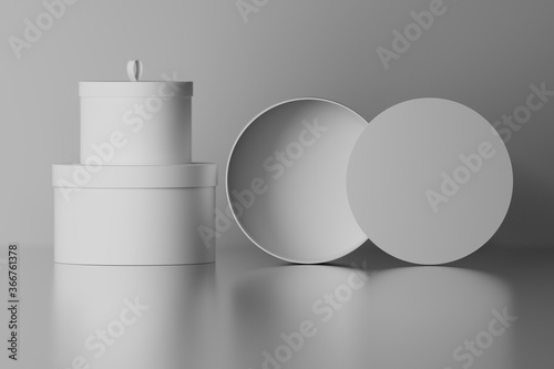 Collection set of round gift packaging boxes with blank surfaces over mirror glossy floor