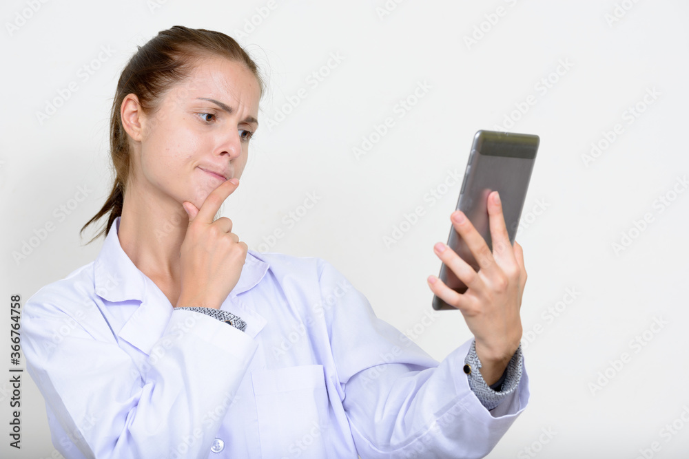 Portrait of young beautiful woman doctor against white background Portrait of young beautiful woman doctor against white background