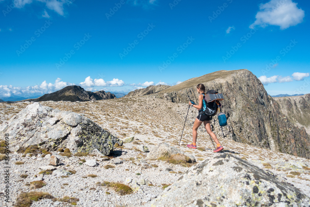 Young trekking woman walking through high alpine pass