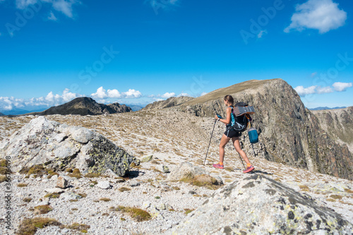 Young trekking woman walking through high alpine pass