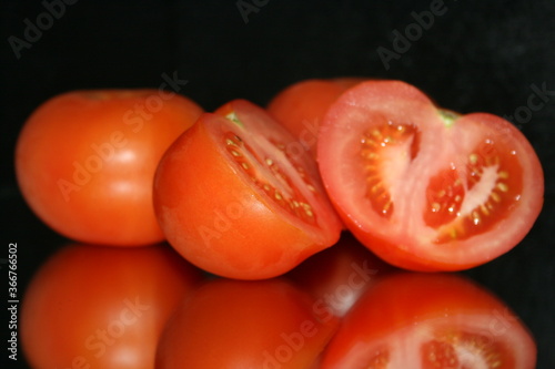 red tasty tomatoes on the black background