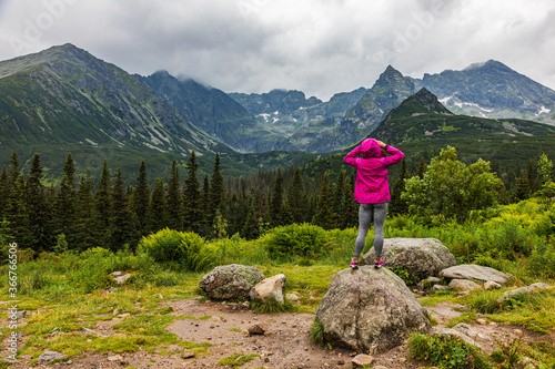 woman in raincoat looking at the Tatra mountain panorama in the rain photo