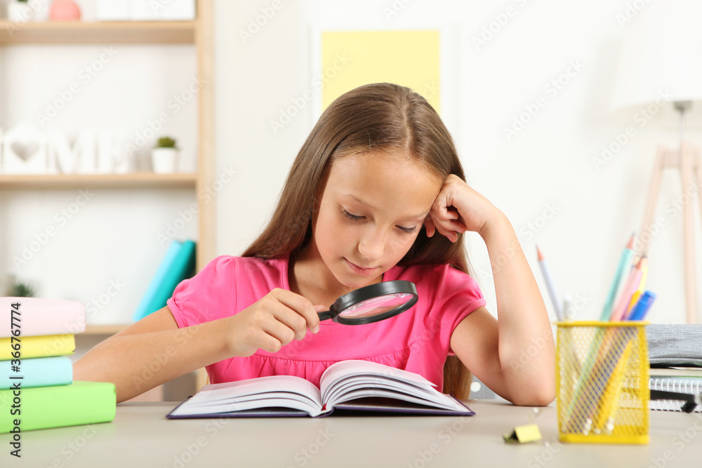 Cute little girl with poor eyesight reads with a magnifying glass
Cute little girl with poor eyesight reads with a magnifying glass