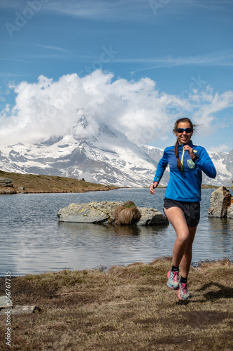 Female trail runner with matterhorn and lake in background, Switzerland