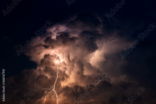 Dark cloud at  night with thunder bolt. Heavy storm bringing thunder, lightnings and rain in summer. photo