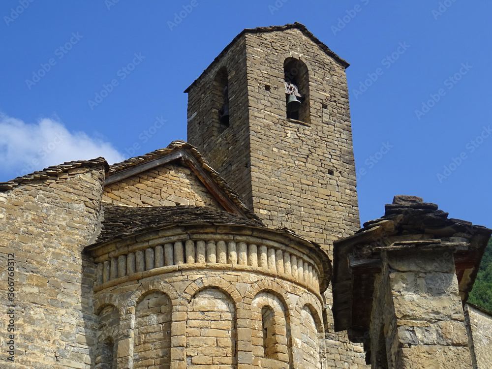 View of the semicircular apse and bell tower of the Romanesque Church of San Martin in the village of Olivan. 11th century. Serrablo Region. Aragón. Spain.  