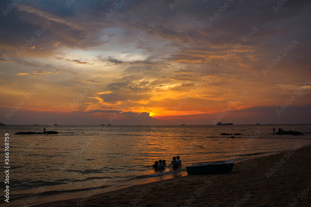 A family bathing in the sea on Ba Keo Beach at sunset, Phu Quoc, Vietnam