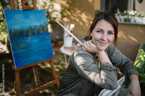 Photo Lady sitting in garden art studio and looking at camera