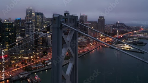 Business and financial city skyline, San Francisco, Silicon Valley, USA. Cinematic aerial panorama of beautiful downtown San Francisco and Bridge at night. Scenic fog over illuminated skyscrapers, 4K