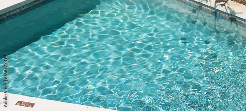 Abstract Blue Clean Water Texture in Swimming Pool with Flecks of Sunlight in Nice Sunny Day – Nature Background, Banner, Copy Space. Top View. © Olga