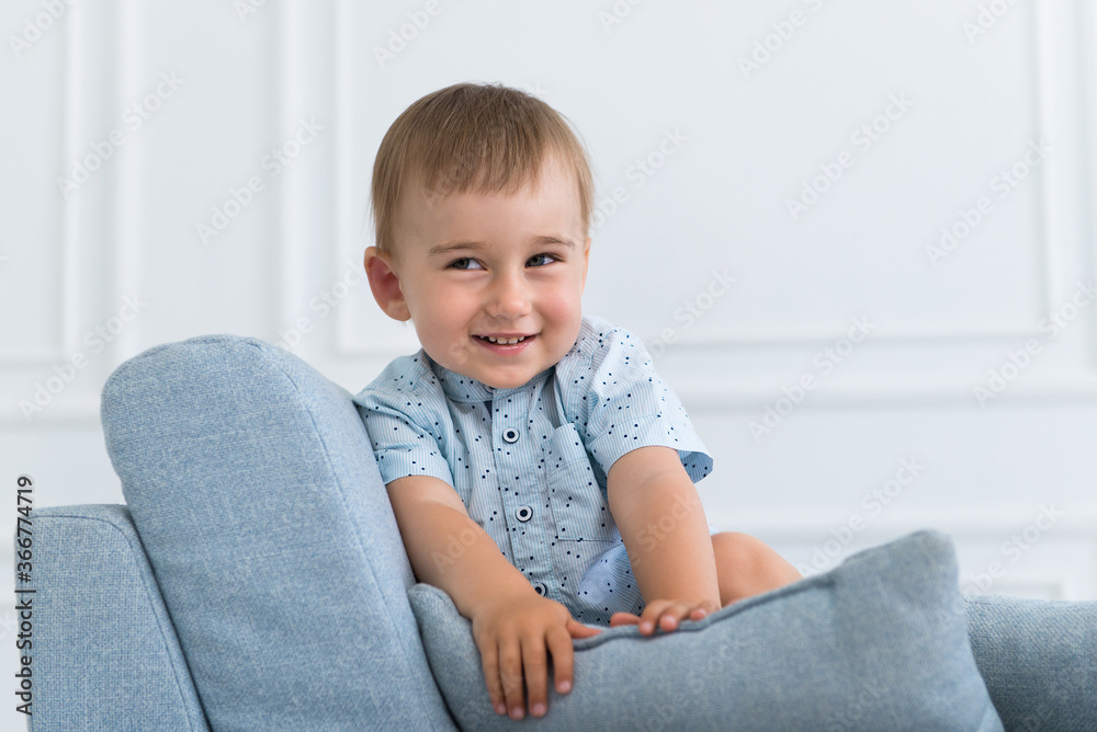portrait of a little smiling boy child playing on the sofa in living room portrait of a little smiling boy child playing on the sofa in living room