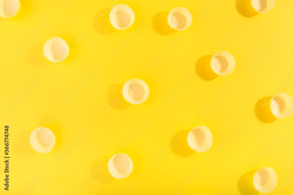 Trendy pattern made with yellow cap on bright yellow background.