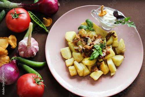 Fried chanterelles and potatoes with herbs and vegetables.Texture or background photo