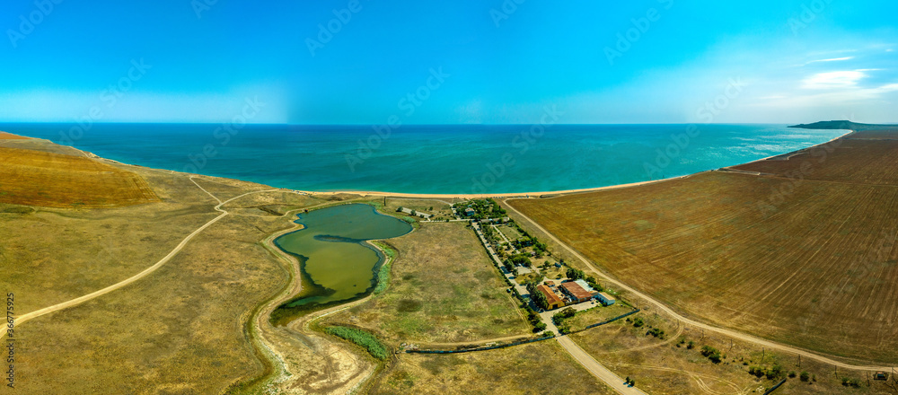 Black Sea coast and lake near the village of Yakovenkovo (Crimea, South of Russia) with sandy beach 