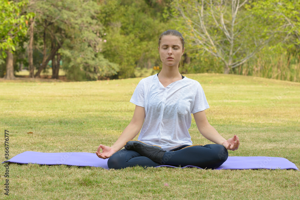 Young beautiful woman exercising at the park outdoors Young beautiful woman exercising at the park outdoors