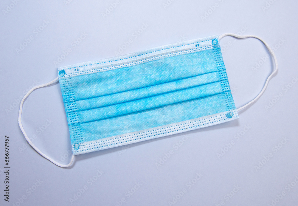 Three-layer surgical mask for covering mouth and nose from bacteria. Protection concept. Three-layer surgical mask for covering mouth and nose from bacteria. Protection concept.