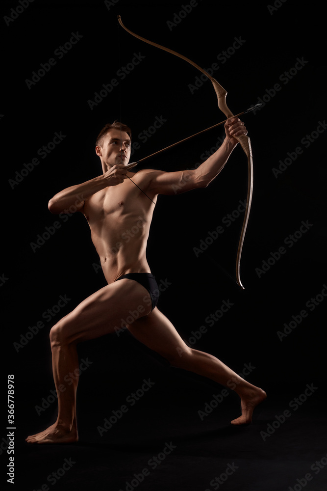 Fototapeta premium Athletic archer shooting with bow.