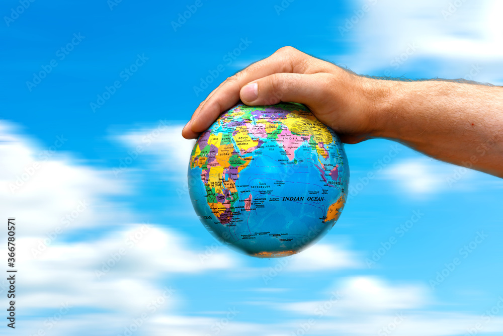 Conceptual symbol human hands surrounding the Earth world globe. the sky in motion