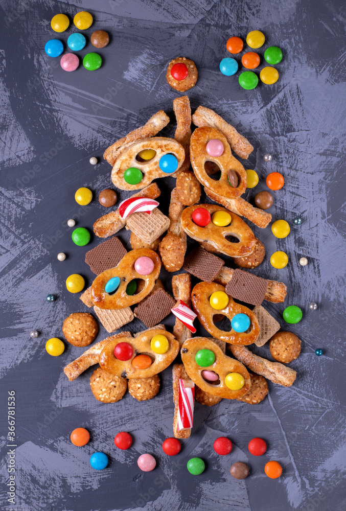 Christmas tree made of different cookies, waffles and candies. Creative holiday background