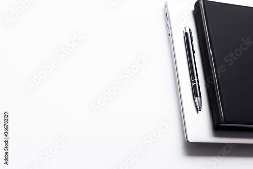 view from above on white office table with notepad, computer and pen