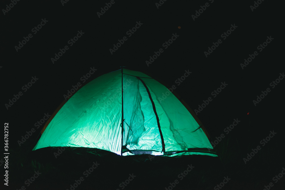 Green tourist tent at night background.