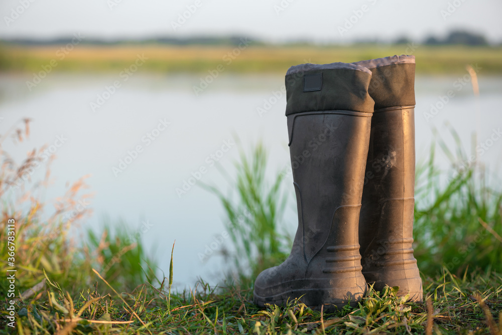 Rubber boots on the lake shore close up. Rubber boots on the lake shore close up.