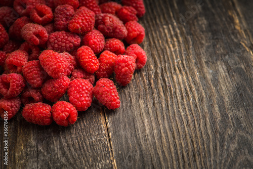 Freshly harvested raspberry on the rustic wooden background. Selective focus. Shallow depth of field. 