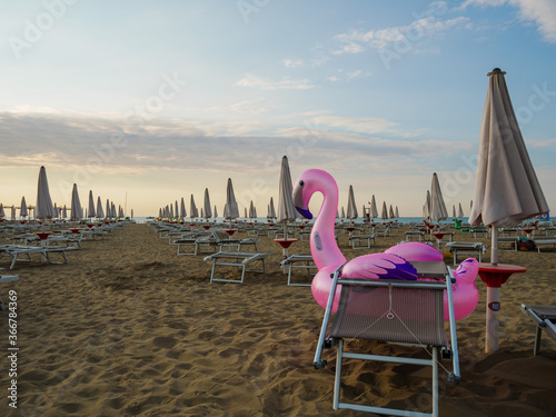 Pink inflatable mattress Flamingo on the beach close-up. Summer and holiday concept. © avanzimg
