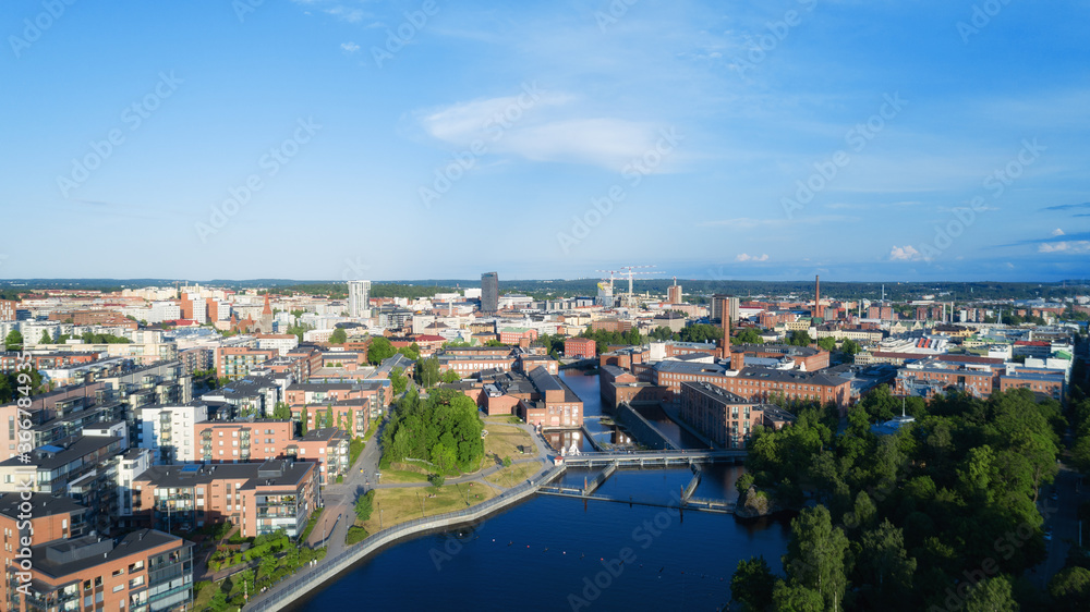 Aerial view of the Tampere city at sunset. Tampella building. View over Tammerkoski river in warm sunlight.