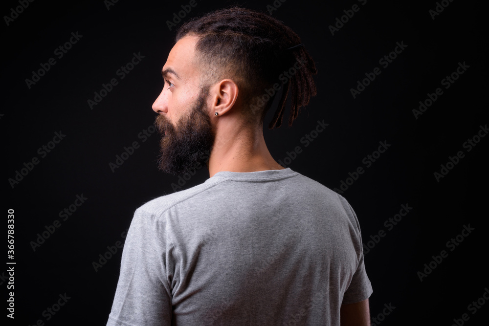 Young handsome Persian man with dreadlocks against black background Young handsome Persian man with dreadlocks against black background
