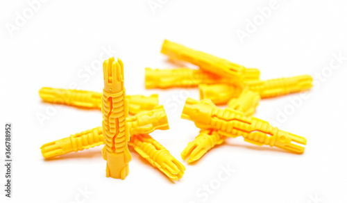 Plastic dowel in yellow close up isolated on white.