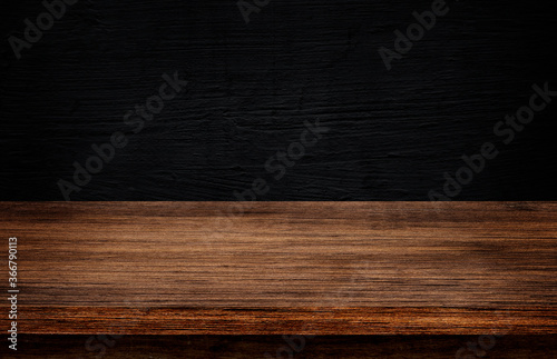 Side view of Empty wooden table top with dark concrete wall texture background for product showing.