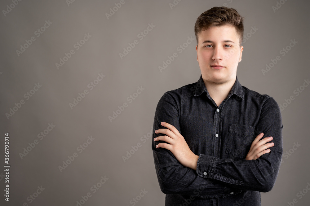 Portrait of serious stylish attractive man dressed with a casual black shirt standing with arms crossed Portrait of serious stylish attractive man dressed with a casual black shirt standing with arms crossed