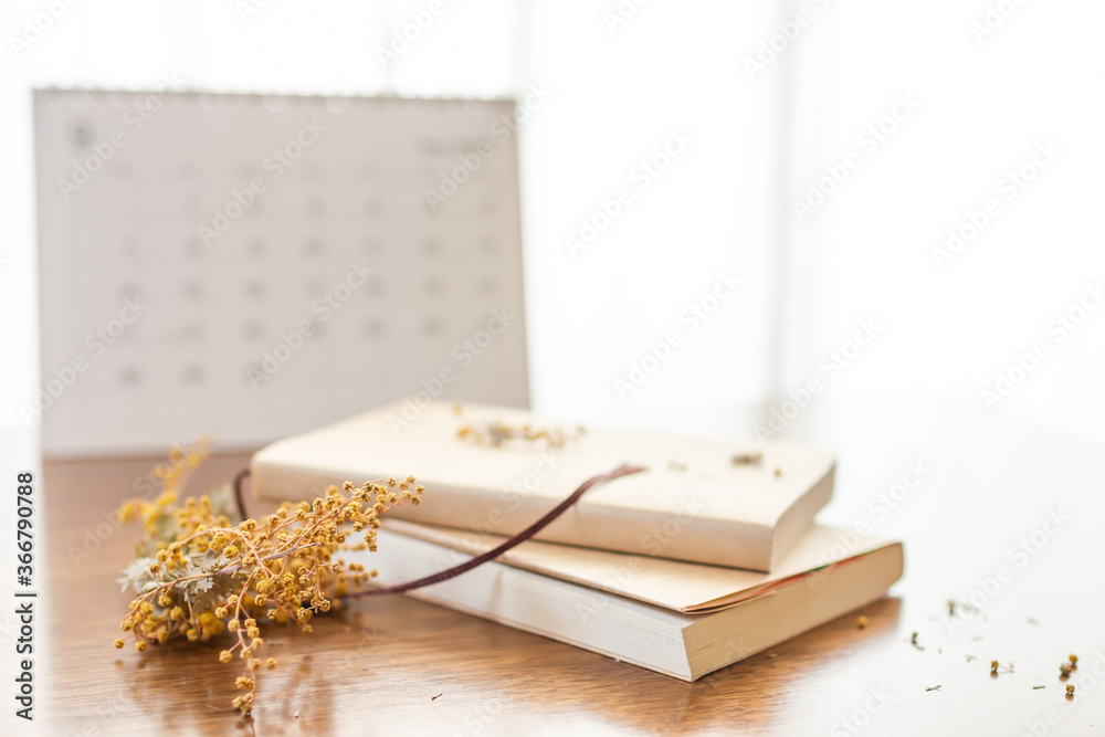 Obraz premium 読書の秋のイメージ画像にミモザとカレンダーを添えて