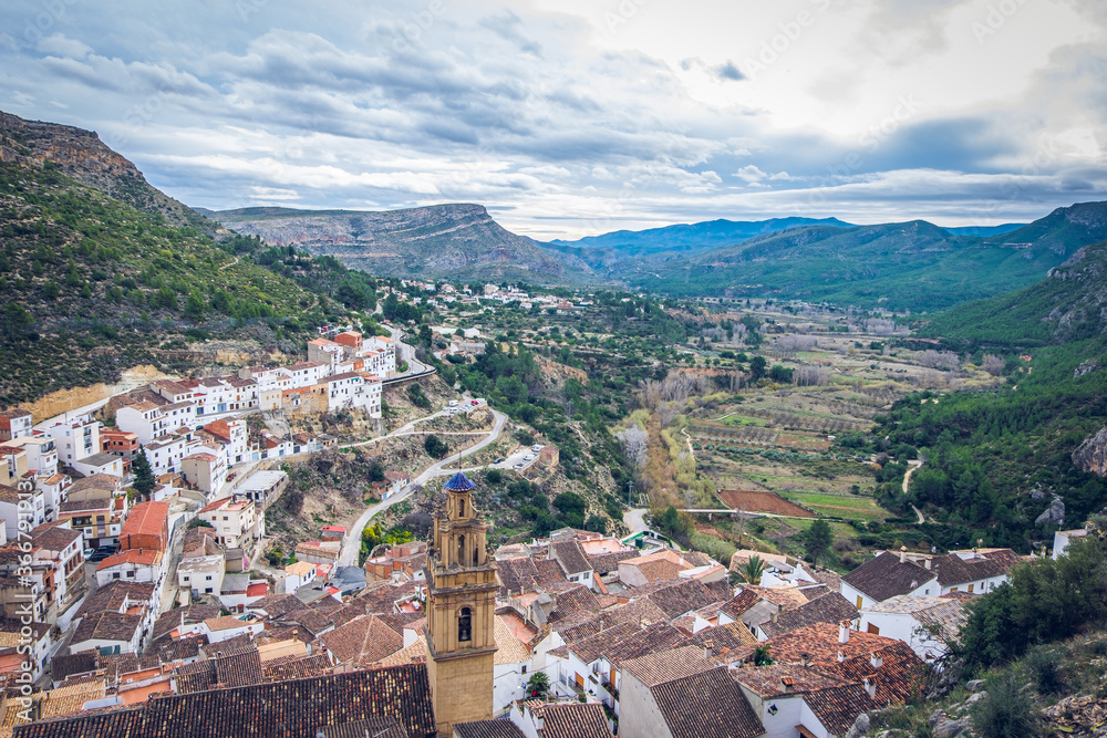 Village Chulilla from the top, rooftops and tower of church Inglesia de la Virgen de los Angeles, with mountain background. Los Serranos, Valencia, Spain.