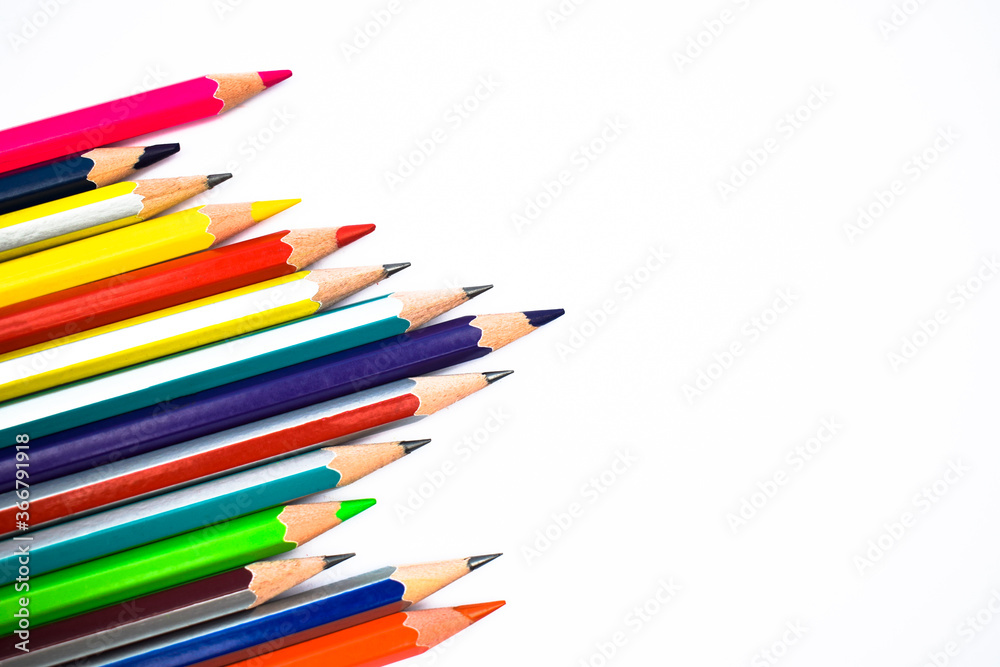 Some different color wood pencil crayons scattered across a white paper