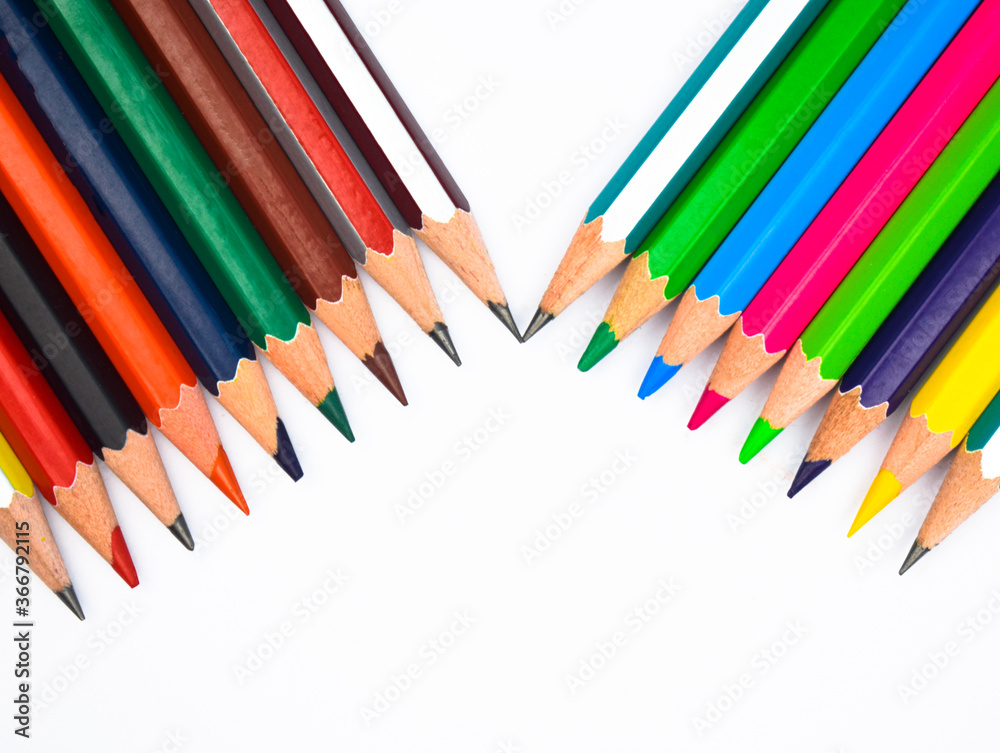 Two different row of different colored wood pencil crayons with one beside another Two different row of different colored wood pencil crayons with one beside another