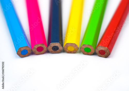 Back side of six different colored wood pencil crayons on a white background