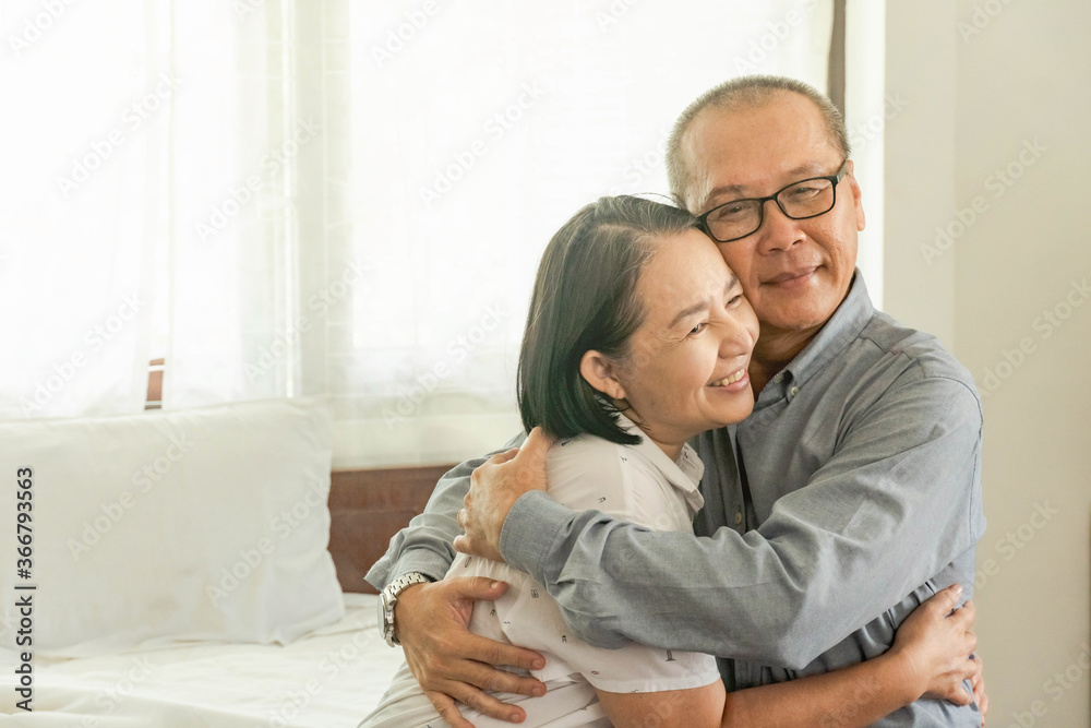 Happy Mature couple romantic flirting and hugging on a comfortable bed or sofa at home in the morning. Retirement, Older Lover and family concept.Copy Space Happy Mature couple romantic flirting and hugging on a comfortable bed or sofa at home in the morning. Retirement, Older Lover and family concept.Copy Space