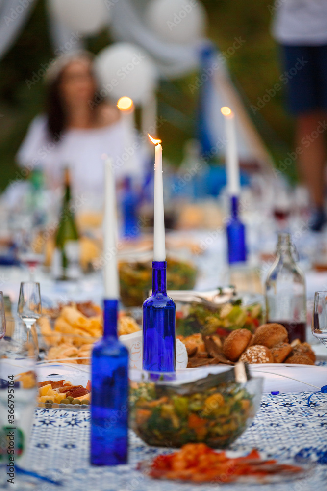 A candle in a blue bottle on the Banquet table