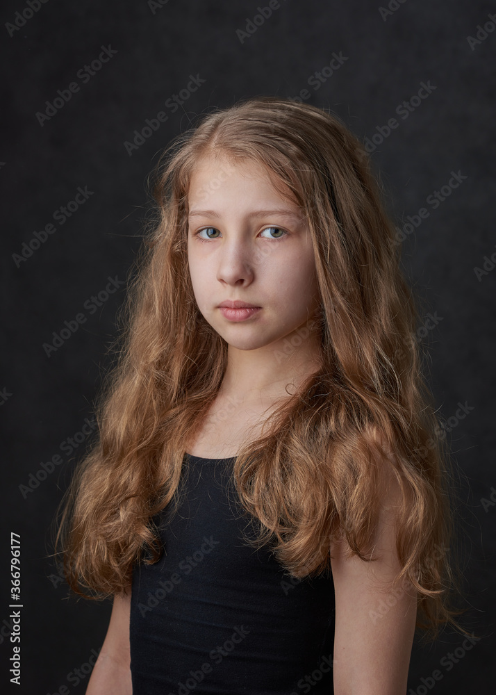Fototapeta premium Portrait of a young long haired girl looking at camera