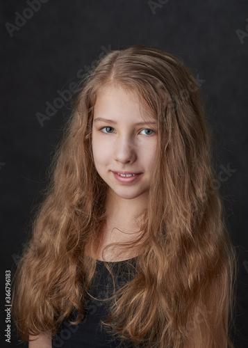 Portrait of a young long haired smiling girl looking at camera