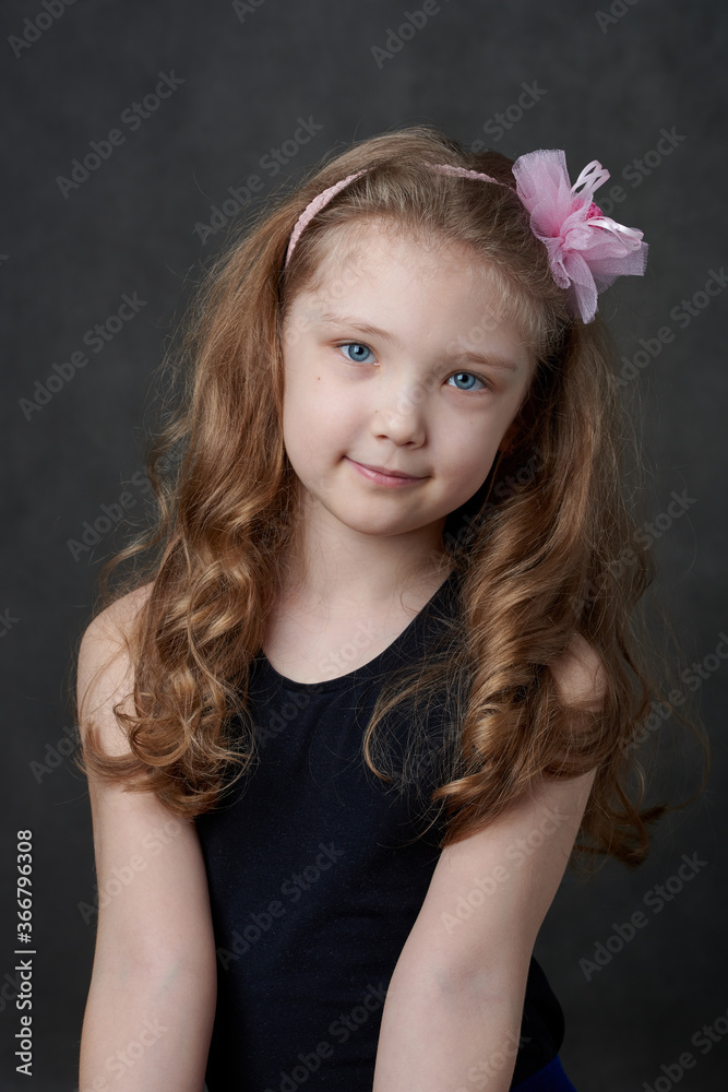 Portrait of a young long haired girl wearing rose hairband and looking at camera