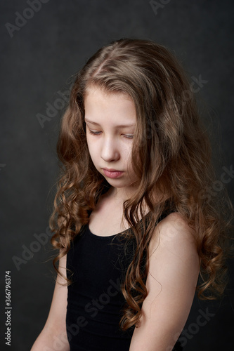 Portrait of a young long haired girl looking down