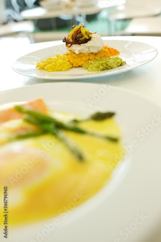 Fine dining food and drink being prepared and displayed in classic white crockery in a kitchen environment,