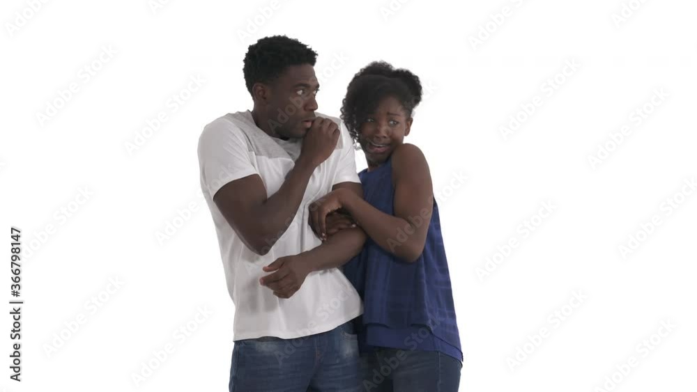 Portrait of scared black couple terrified pointing to the right side, closing face in fear, girl trying to hide behind guy isolated on white background. Human emotion concept. Portrait of scared black couple terrified pointing to the right side, closing face in fear, girl trying to hide behind guy isolated on white background. Human emotion concept.