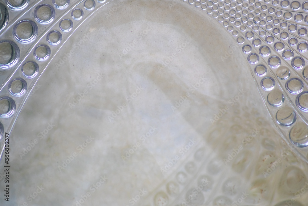 Abstract circle pattern in a glass brick as glass background shows a symmetric and elegant design in transparency like waves and fluent design in glass Abstract circle pattern in a glass brick as glass background shows a symmetric and elegant design in transparency like waves and fluent design in glass