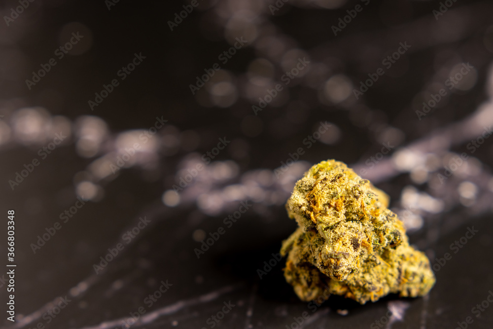 Close up of cannabis bud on black marble background
