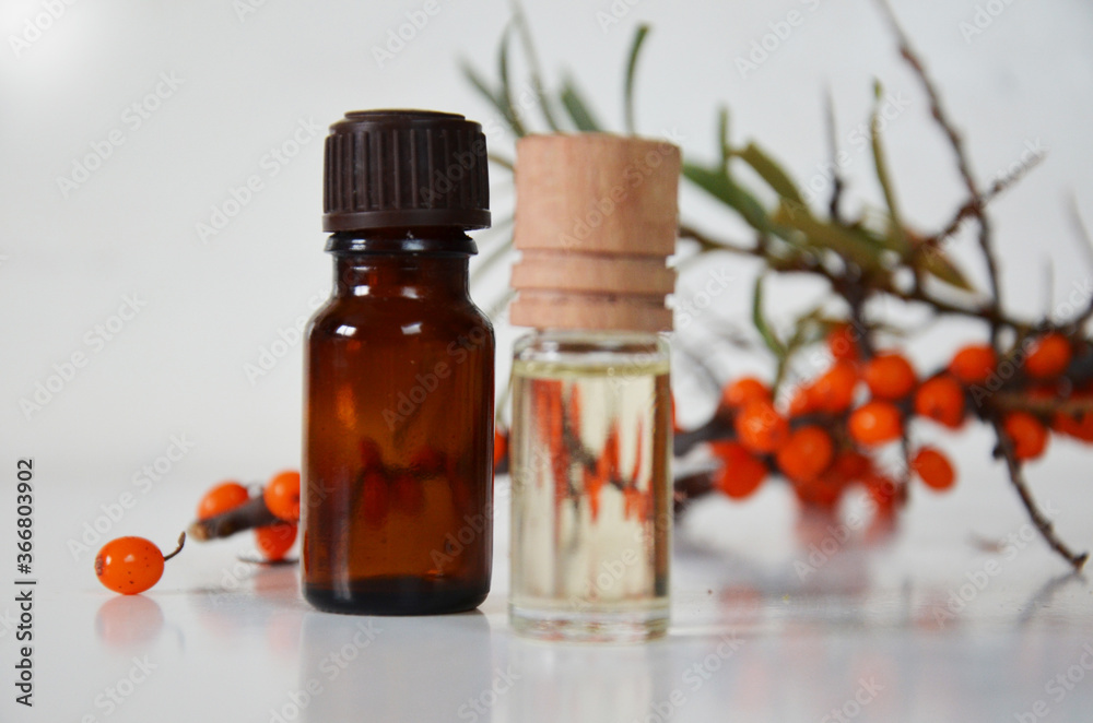 sea-buckthorn berries cluster and oil bottle jar isolated on a white background sea-buckthorn berries cluster and oil bottle jar isolated on a white background