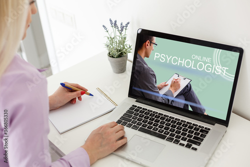 Woman in front of her laptop having an online call with her therapist, text space